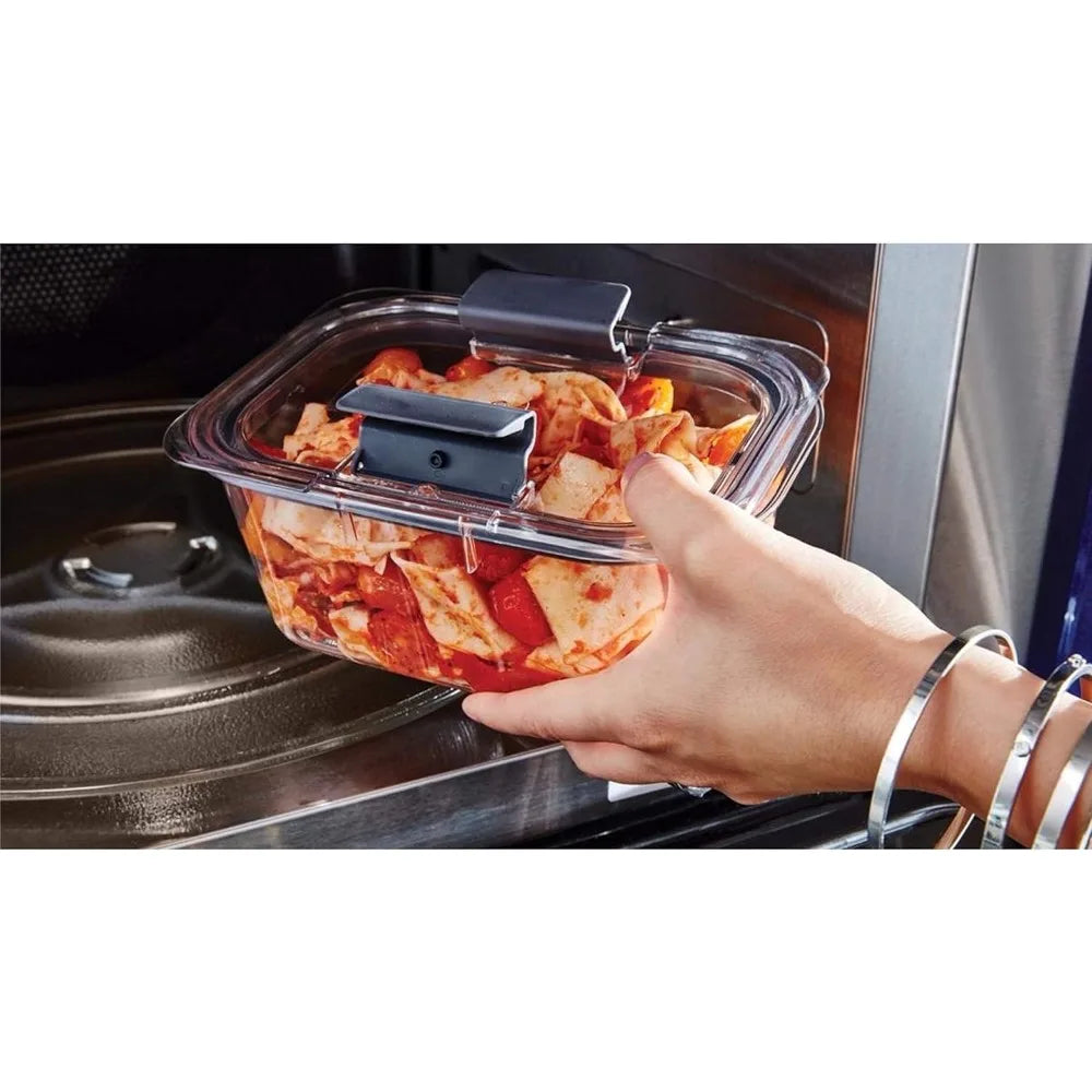 Hand holding a container of food above an open oven