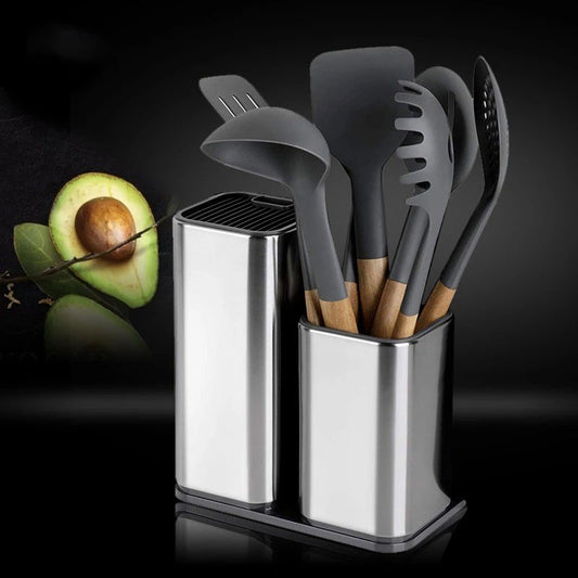Set of gray kitchen utensils in a metal holder with an avocado on a dark background