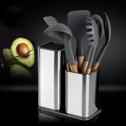 Set of gray kitchen utensils in a metal holder with an avocado on a dark background